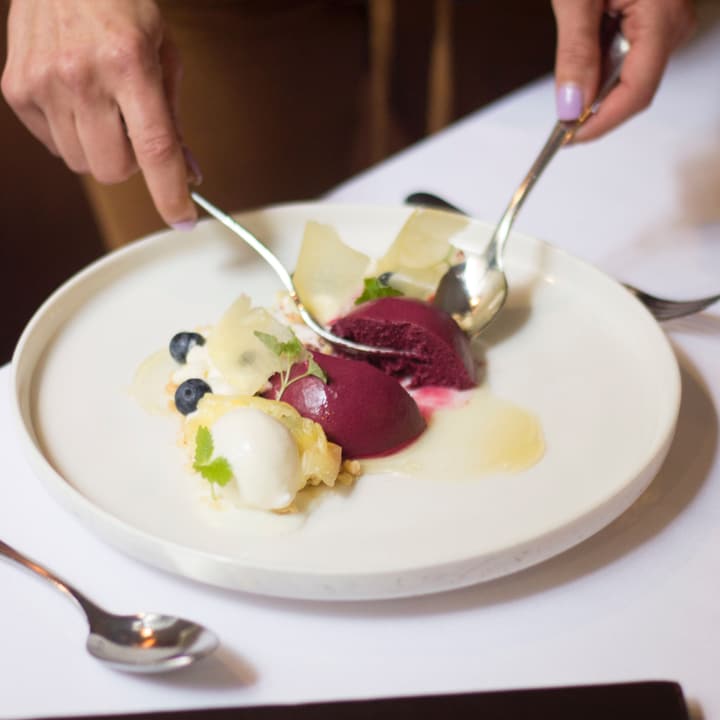 Dolce con quenelle di ricotta, visciole e polvere di mandorla