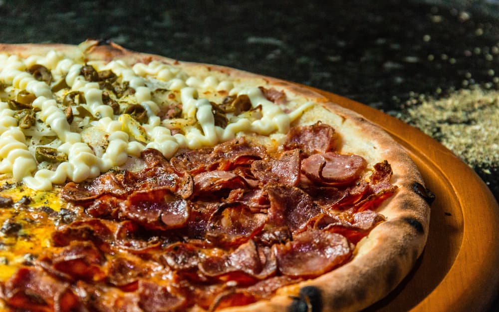 Pizza contemporanea con crema di zucca e ricotta su piano d’acciaio