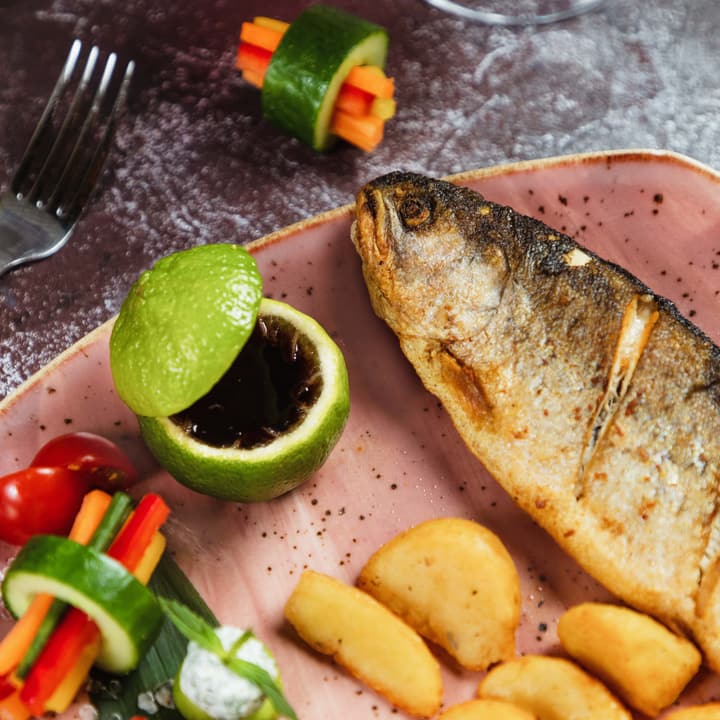 Pescato del giorno alla brace con spicchi di limone