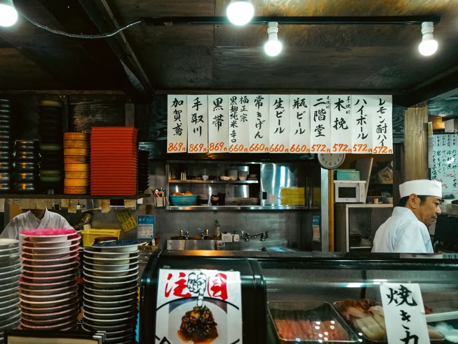 Il banco del sushi illuminato con luci calde sullo sfondo scuro